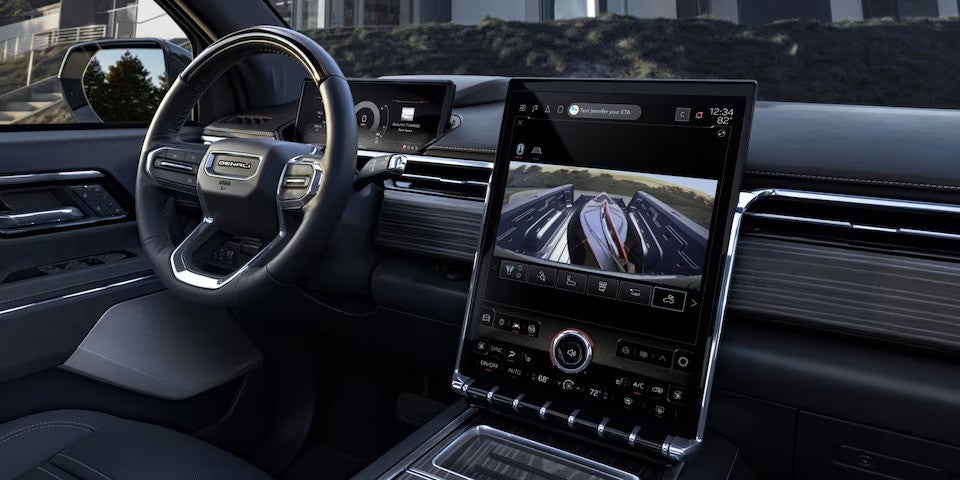 Interior View of the GMC Sierra EV's Steering Wheel and Infotainment System With the Truck Bed Camera in Use