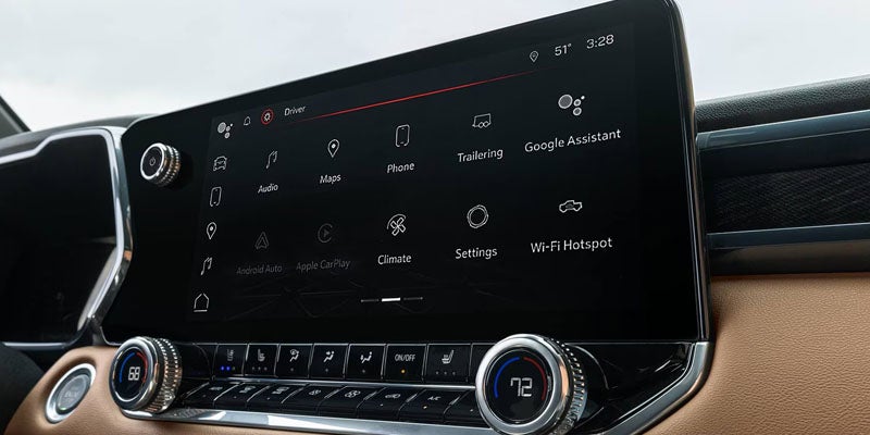 Car infotainment screen showing apps like Maps, Audio, Phone, and Climate, with physical controls below.