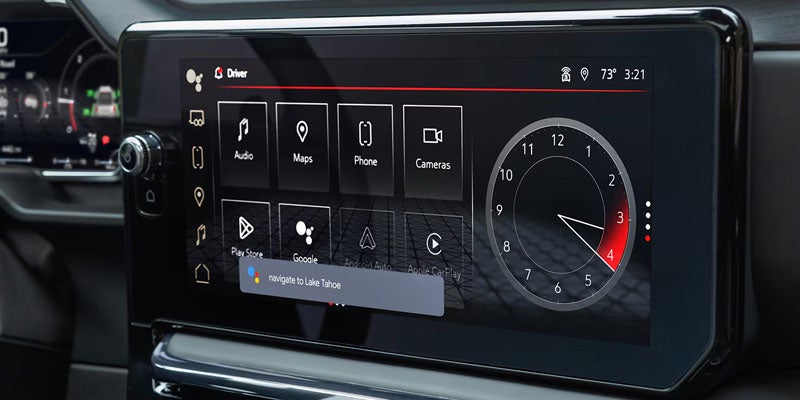 Car's infotainment screen showing app icons (Maps, Audio, Phone) and a clock widget, with a voice command "navigate to Lake Tahoe."